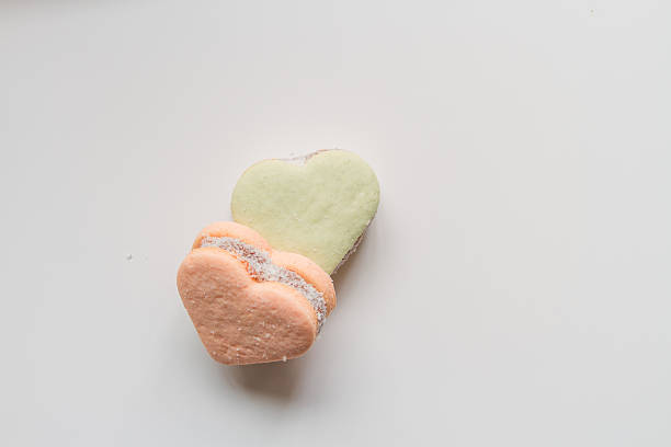 istock Two color alfajores cornstarch with heart shape on white backgro 615276518