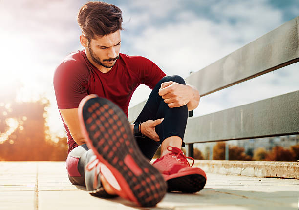 Muscle injury Portrait of a muscle fitness man reaching for his leg in pain stretched leg stock pictures, royalty-free photos & images