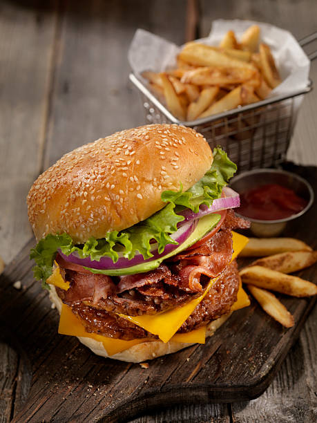 avocado bacon cheeseburger with a basket of fries - take out food fast food vertical tomato imagens e fotografias de stock