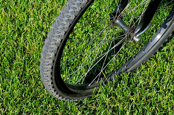 istock Wheel of the mountain bicycle on a green grass 615281162