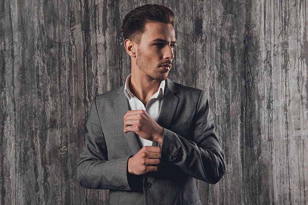 istock Handome man in suit fastening buttons on  the sleeves 615281226