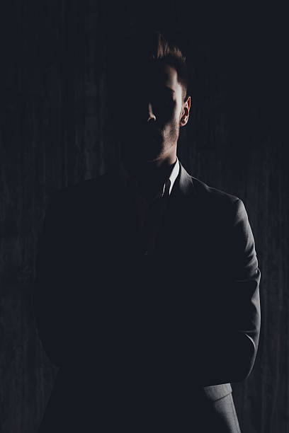 dark photo of serious man in suit - smoking issues fotos imagens e fotografias de stock
