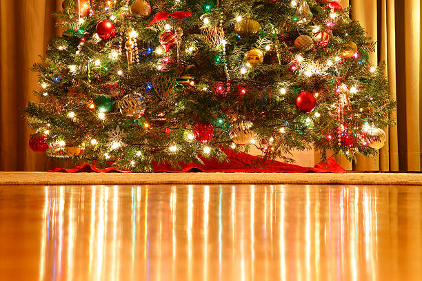lights reflect off harwood floor from lit christmas tree - harwood floor imagens e fotografias de stock