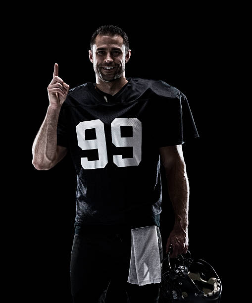 istock Smiling American football player pointing up 615286686