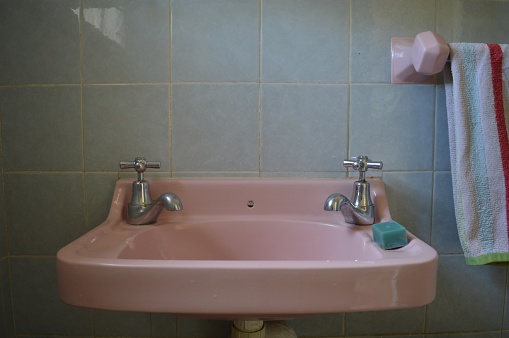 Soap And Old-Fashioned Taps On Pink Bathroom Sink