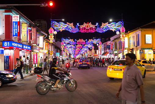 Singapore, Singapore - October 08, 2016: People crossing the road juction of Serangoon Road and Upper Dickson Road during a weekend evening, Serangoon Road is decorated for Deepavali / Diwali festive Season.