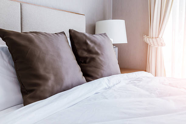 istock Bed maid-up with clean brown pillows 615390524