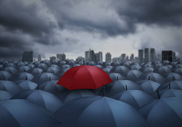 istock red umbrella outstanding from the others, chosen concept 615390726