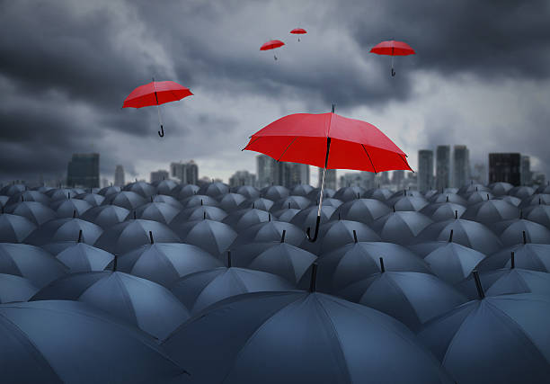 istock red umbrella outstanding from the others, chosen concept 615390756