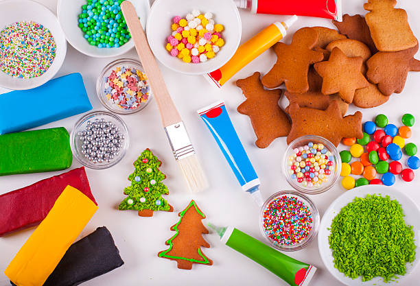 istock Decorating Christmas tree shaped gingerbread cookies with green icing 615390814
