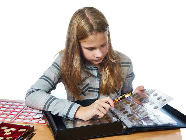 istock Girl inspecting her collection coins isolated 615391824