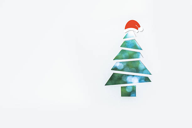 istock cut paper tree shaped with santa hat on 615395522