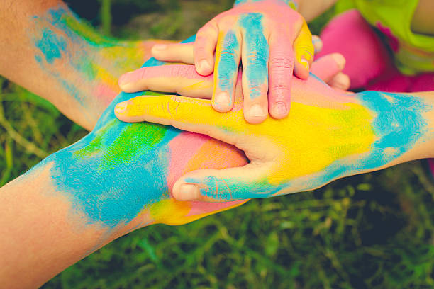 istock Four hands painted in different colors. 615395994