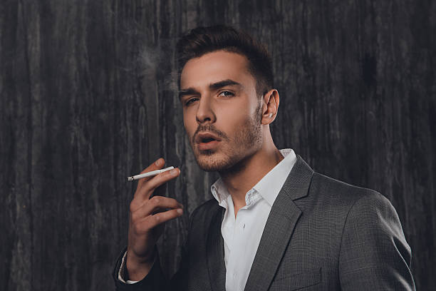 handome sexy mann im anzug rauchen eine zigarette - smoking smoking issues cigarette addiction stock-fotos und bilder