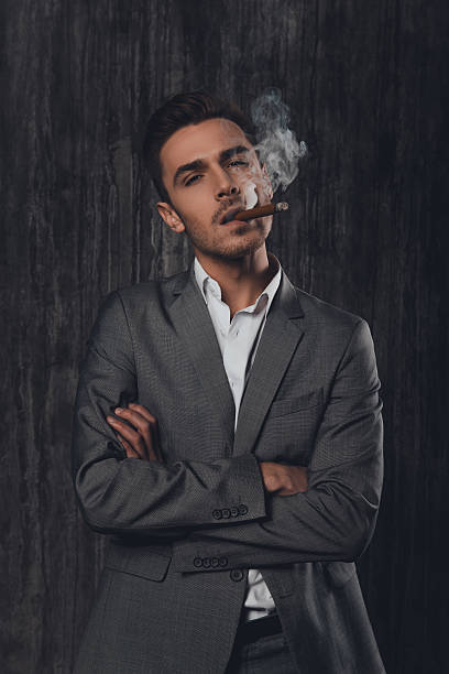 istock Handome brutal man in suit with a sigar 615398020