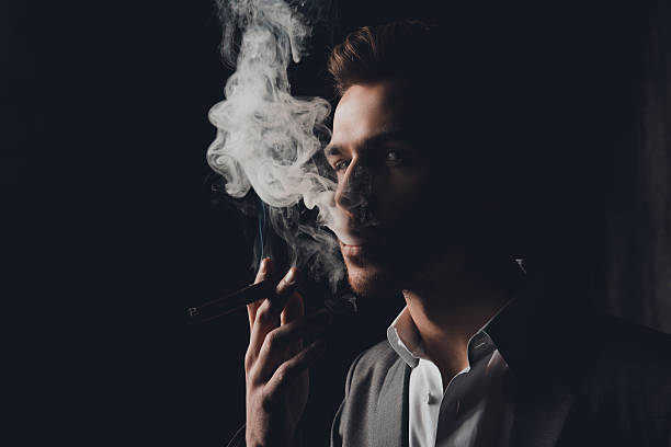 handome mann im anzug rauchen eine zigarre - smoking smoking issues cigarette addiction stock-fotos und bilder