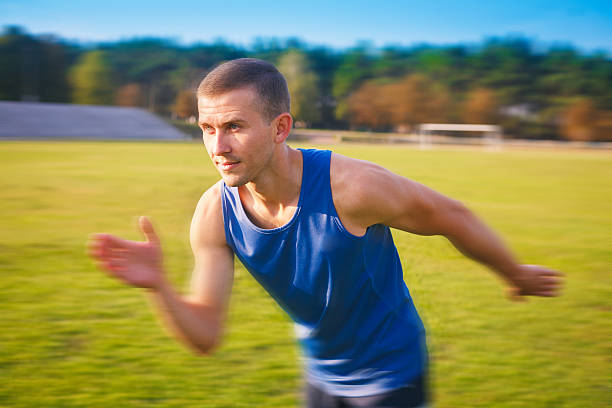 young handsome sportsman running outdoors. - playing field effort outdoors human age imagens e fotografias de stock