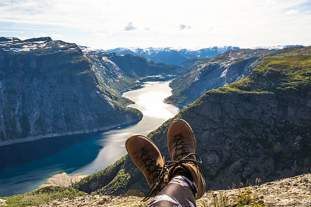 istock Happy hiker relax on Trolltunga. Mane enjoy beautiful lake and 615401318