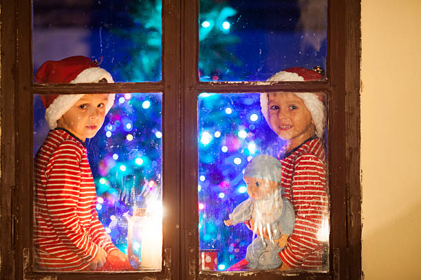 istock Two children, boys, sitting on a window at night 615403586