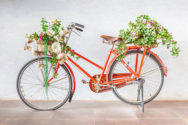 istock Vintage red bicycle with flower baskets parking against cement wall. 615403864