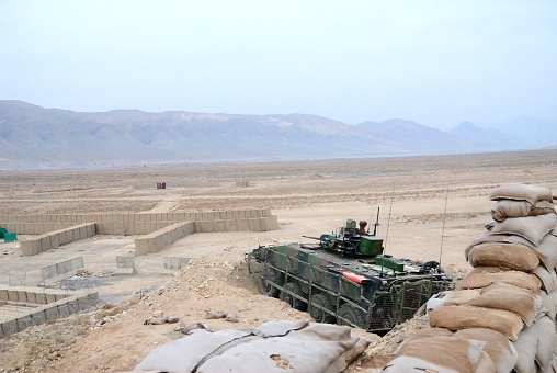 Gwan, Afghanistan - December 19, 2011: High angle view of armored tank at military battlefield in desert during mission. 