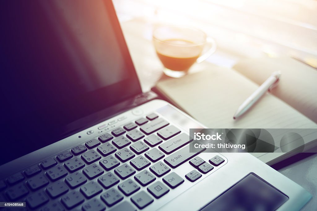 Vintage style work office desk with a cup of coffee Vintage style work office desk with a cup of coffee computer laptop on table in home interior, filtered image, focus on keyboard Breakfast Stock Photo