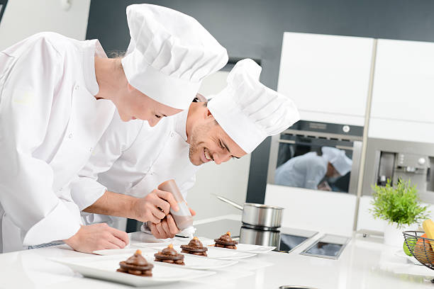 student and teacher professional cook school kitchen preparing chocolate dessert