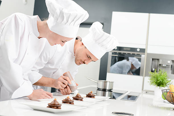 istock student and teacher professional cook school kitchen preparing chocolate dessert 615410398