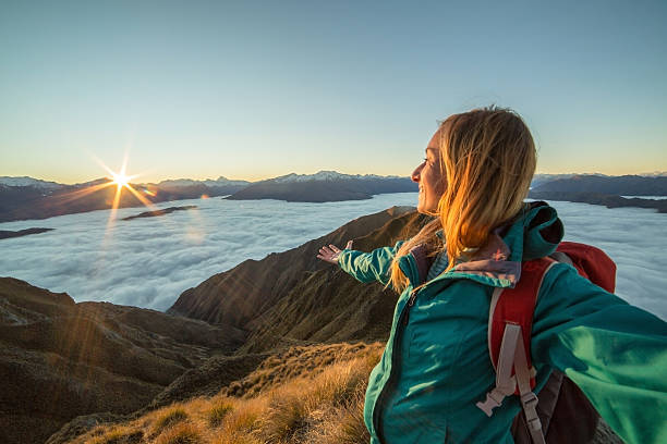 istock Female hiker over the clouds, sunset 615410664