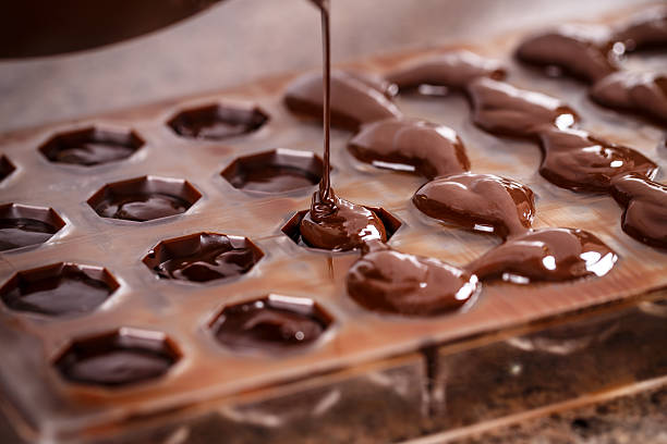 Putting chocolate in mold stock photo