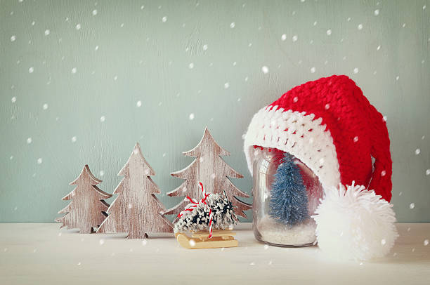 istock cute knitted santa hat on mason jar with christmas tree 615413228