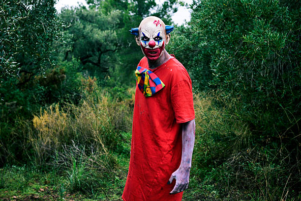 istock scary evil clown in the woods 615413702