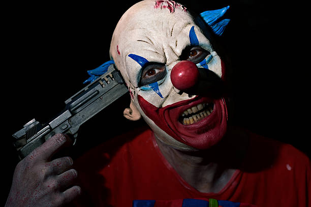 istock evil clown pointing a gun to his temple 615414062