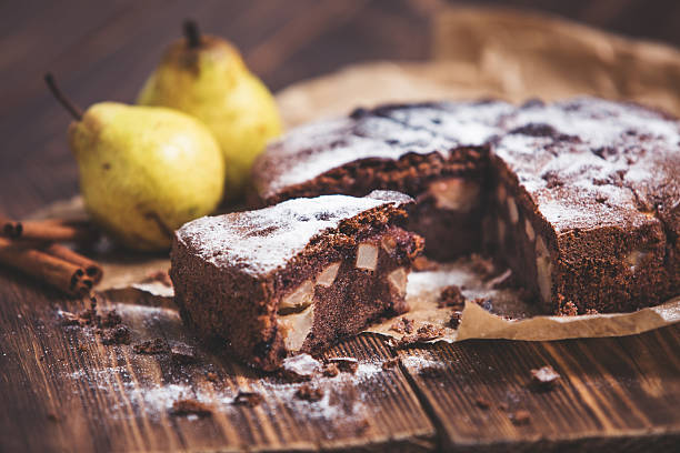 Homemade chocolate pie with pears and cinnamon on the wooden rustic table