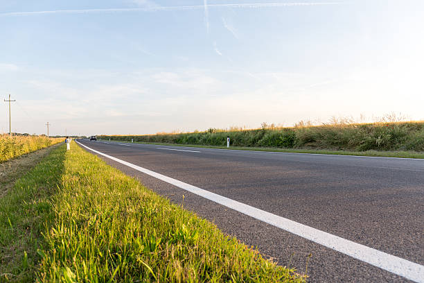 istock Asphalt road & Yellow field cloudy sky in summer day 615415396