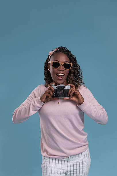 istock Young african woman photographing 615416330