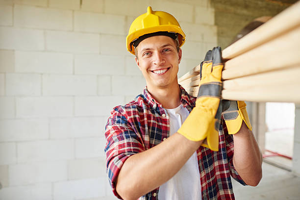 istock Younger carpenter holds wooden planks 615418672
