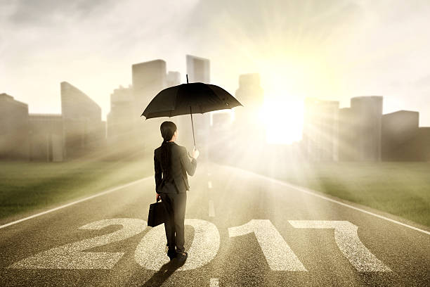 istock Worker with umbrella and 2017 at street 615419426