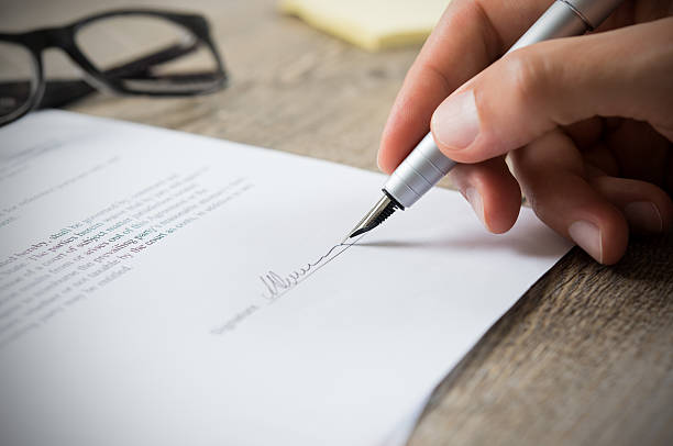 Man signing contract Close up of hand of businessman signing a form. Business man signing contract for future deal. Business man signing legal document. Male hand signing employee contract with a bond. contract stock pictures, royalty-free photos & images