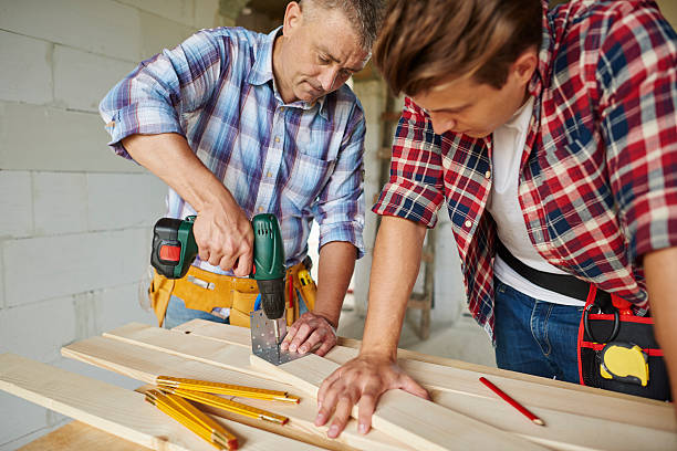 istock Senior carpenter is drilling  wooden planks 615420078