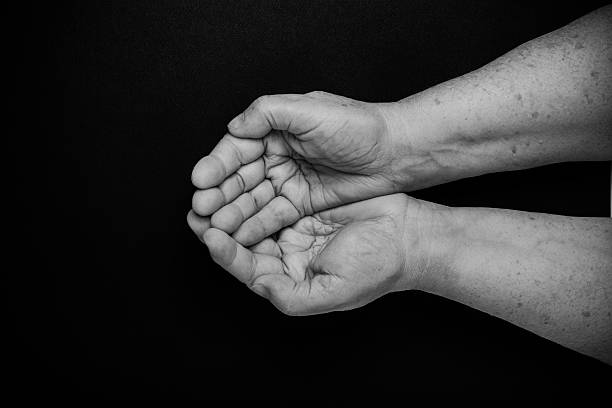 istock Hands of elderly woman on black background. Toned 615420810