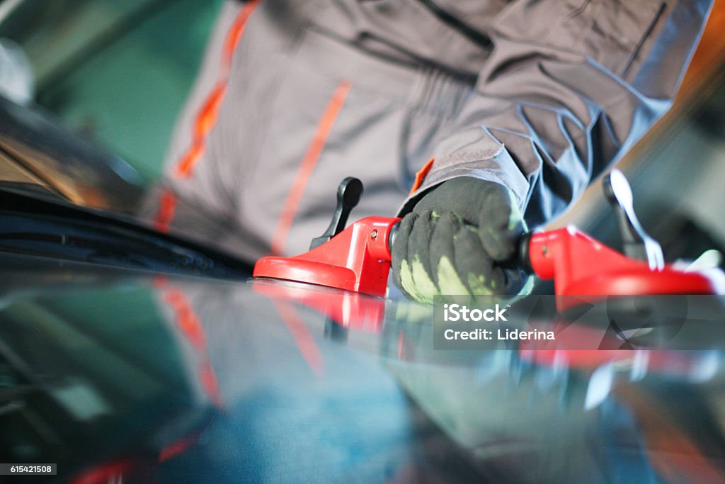 Mechanic changing glass. Mechanic changing glass in his workshop.Focus on hand. Car Stock Photo