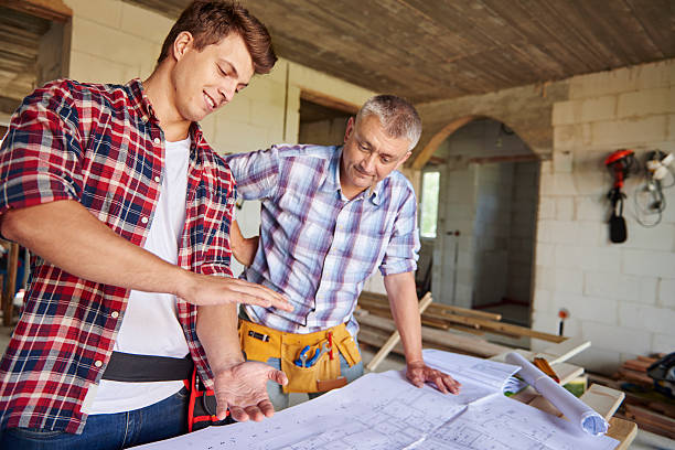 istock Younger of carpenters is demonstrating new idea 615421696