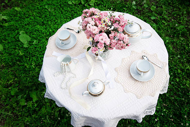 Upper view of the table with pink bouquet and tea cups. Top view.