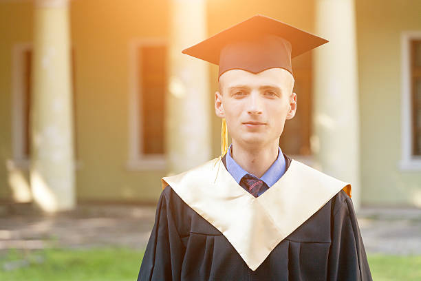 istock Graduate students wearing graduation hat and gown 615425674