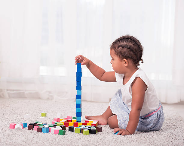 kleines mädchen spielt mit blockwürfeln. - cube baby child block stock-fotos und bilder
