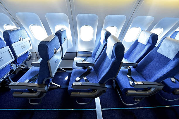 Blue airplane empty seats Blue airplane empty seats with new head rest covers passenger cabin photos stock pictures, royalty-free photos & images