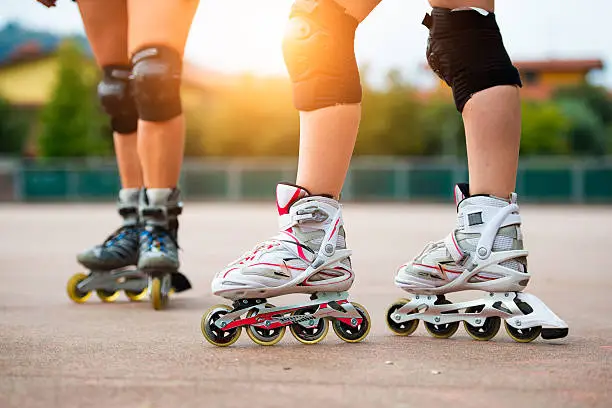 Detail of girls rollerblading with knee pads