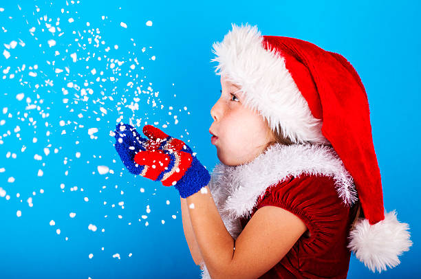 아름다운 어린 소녀 에 산타 클로스 모자 불고 눈송이 - fake snow santa claus christmas christmas decoration 뉴스 사진 이미지