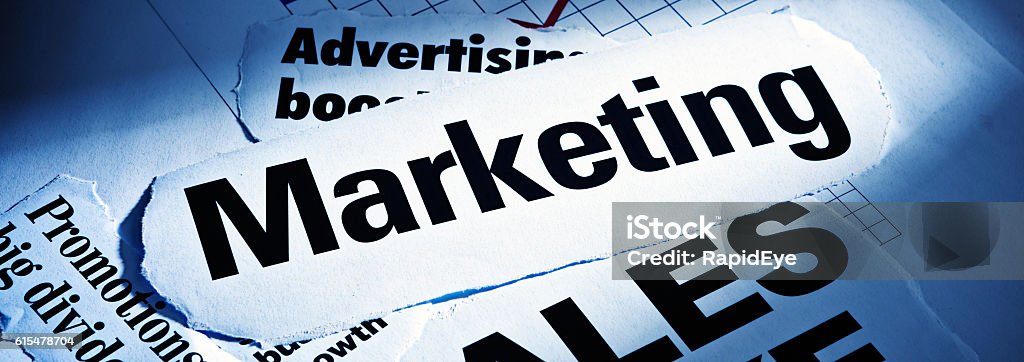 Spotlit headlines on Marketing, Promotions, and Advertising Print headlines about Marketing, Advertising, and Promotions, spotlit and blue toned. Blue Stock Photo